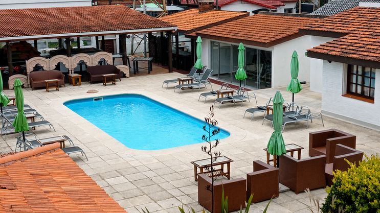 Piscina exterior con reposeras y sombrillas en el Hotel Concorde