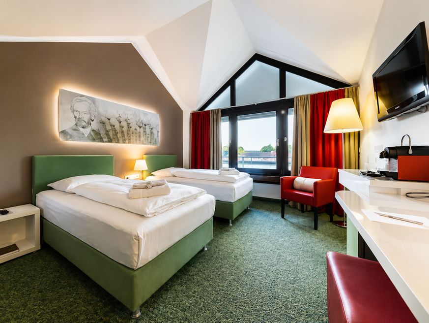 Habitación de hotel limpia y luminosa con ropa de cama blanca y un pequeño balcón